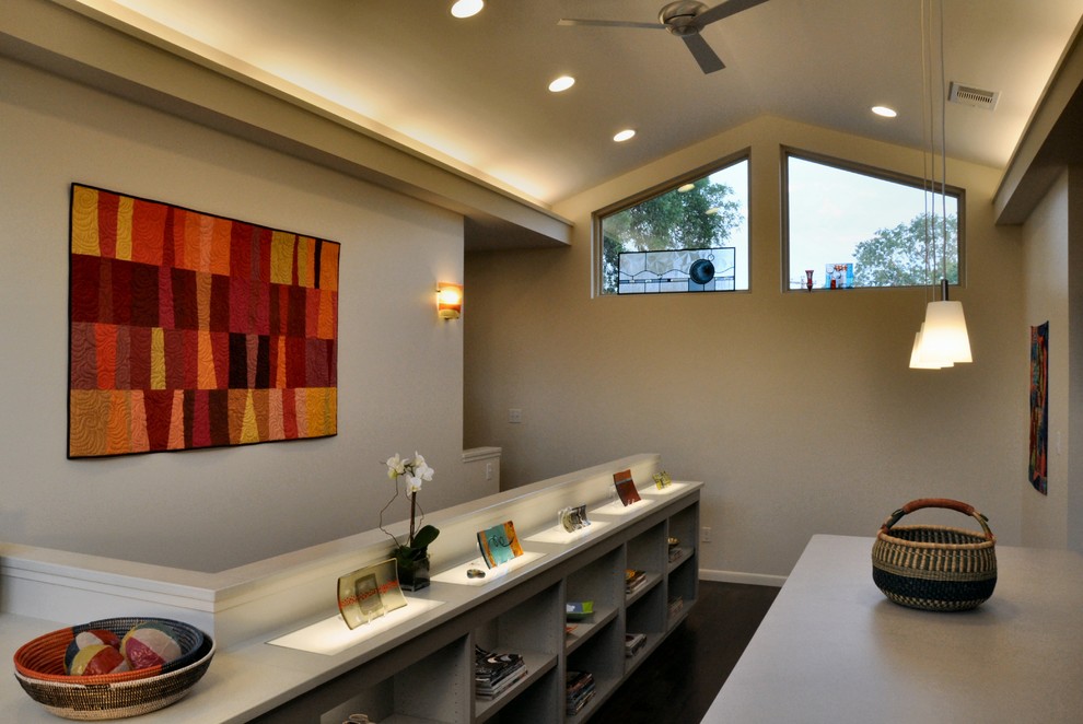 This is an example of a contemporary home office in Austin with beige walls and dark hardwood floors.