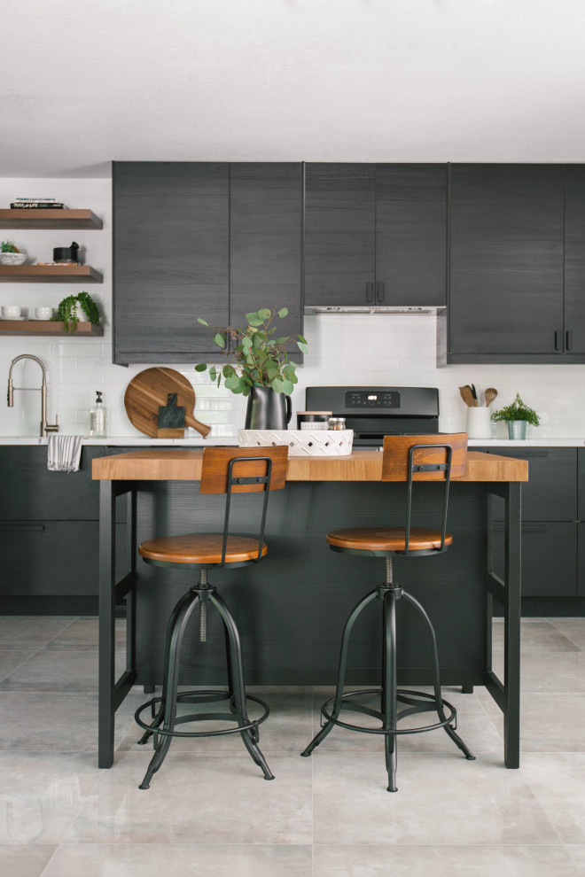Inspiration for a small scandinavian l-shaped kitchen pantry in Tampa with a drop-in sink, flat-panel cabinets, black cabinets, quartz benchtops, white splashback, engineered quartz splashback, black appliances, ceramic floors, with island, grey floor and white benchtop.