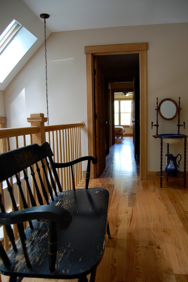Photo of a mid-sized traditional hallway in Boston with beige walls and light hardwood floors.