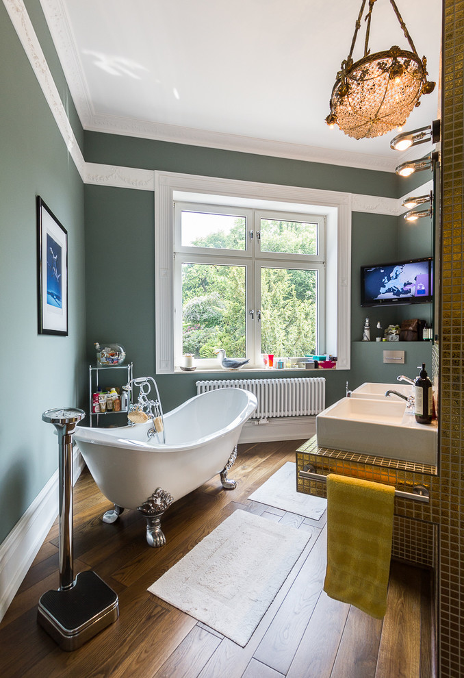 Photo of a mid-sized traditional bathroom in Bari with a vessel sink, a claw-foot tub, green walls, dark hardwood floors, yellow tile, mosaic tile and tile benchtops.