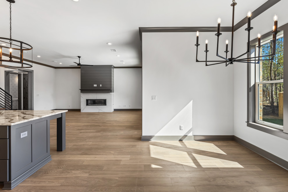Inspiration for a mid-sized transitional medium tone wood floor and brown floor breakfast nook remodel with a ribbon fireplace and a stone fireplace