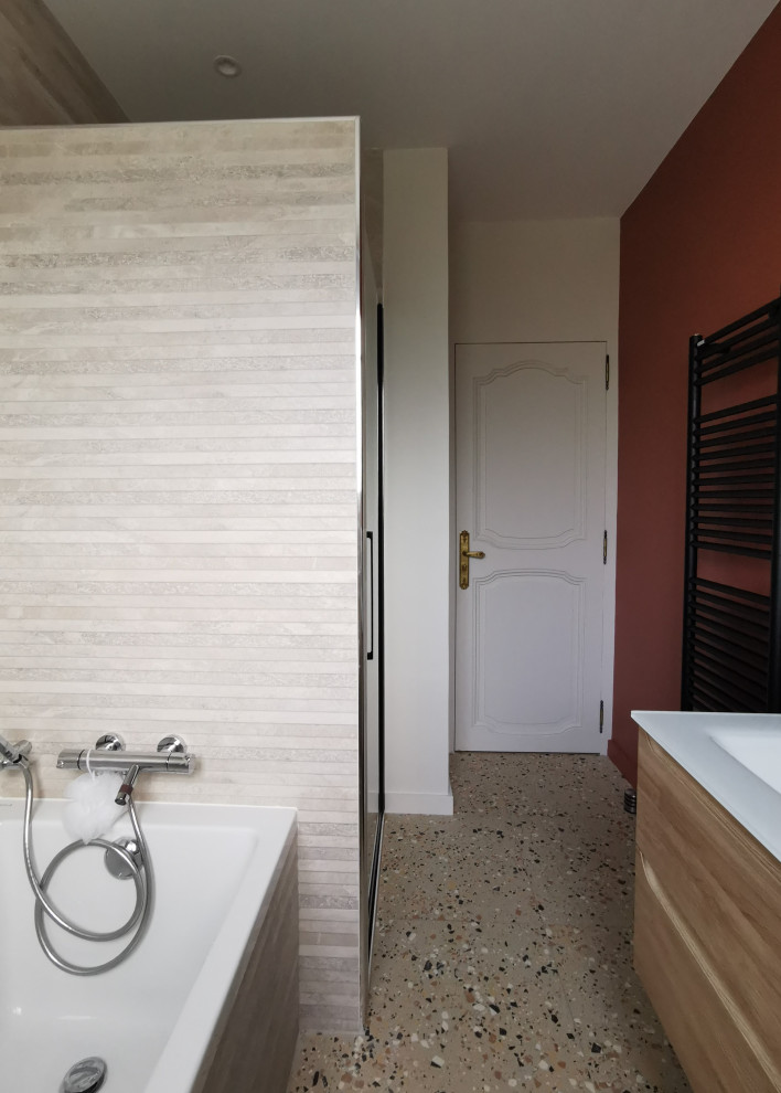 Modelo de cuarto de baño principal, largo y estrecho, doble y de pie de tamaño medio con puertas de armario de madera clara, baldosas y/o azulejos beige, suelo de terrazo, lavabo tipo consola, encimera de vidrio y encimeras blancas