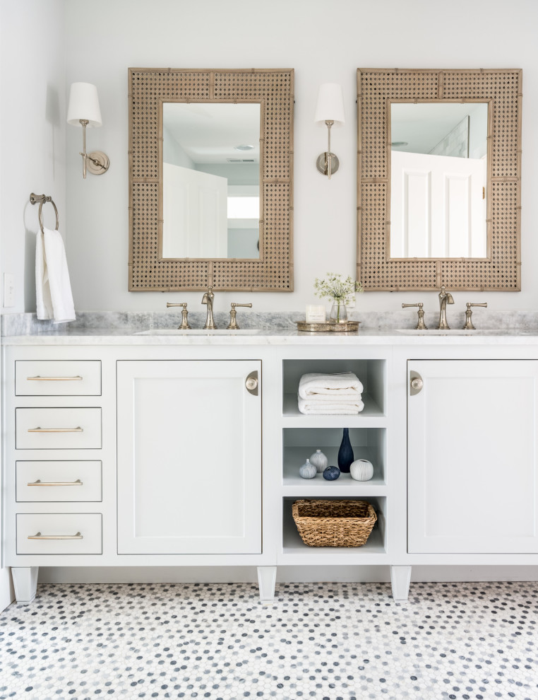 This is an example of a mid-sized country kids bathroom in Nashville with recessed-panel cabinets, white cabinets, an alcove tub, a shower/bathtub combo, a two-piece toilet, gray tile, marble, blue walls, ceramic floors, an undermount sink, marble benchtops, grey floor, an open shower, grey benchtops, a double vanity and a built-in vanity.