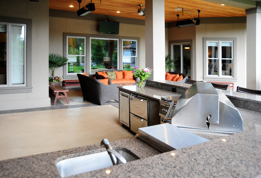 Inspiration for a large transitional backyard patio in Seattle with an outdoor kitchen, stamped concrete and a roof extension.