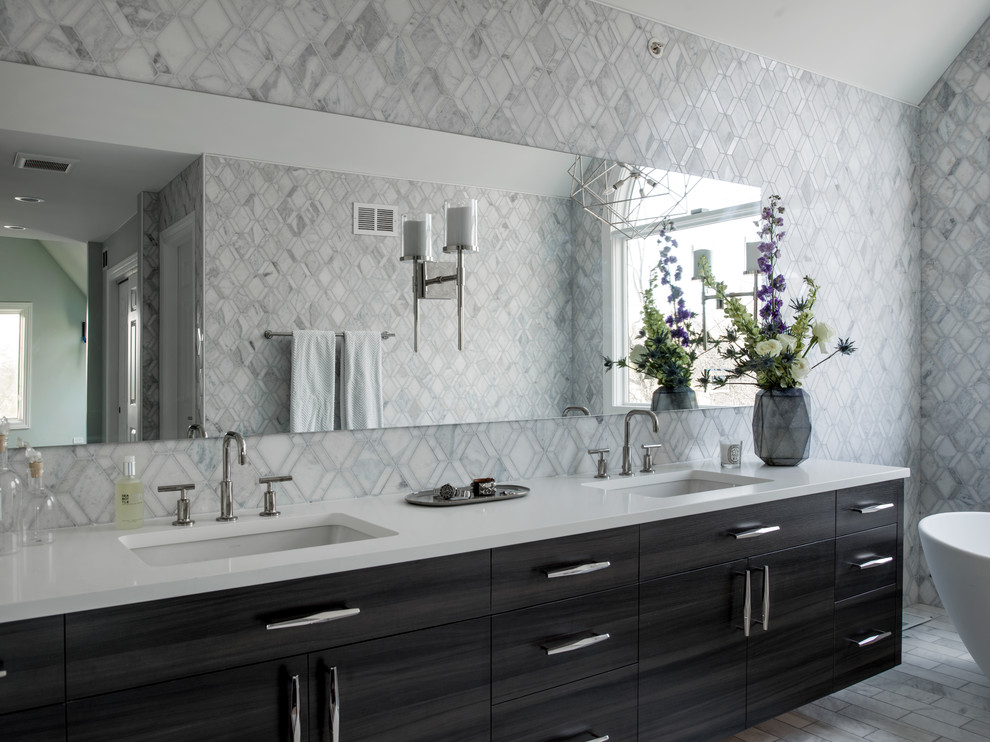 This is an example of an expansive transitional master bathroom in Chicago with flat-panel cabinets, dark wood cabinets, a freestanding tub, an alcove shower, a two-piece toilet, gray tile, white tile, ceramic tile, multi-coloured walls, marble floors, an undermount sink, solid surface benchtops, white floor and a hinged shower door.