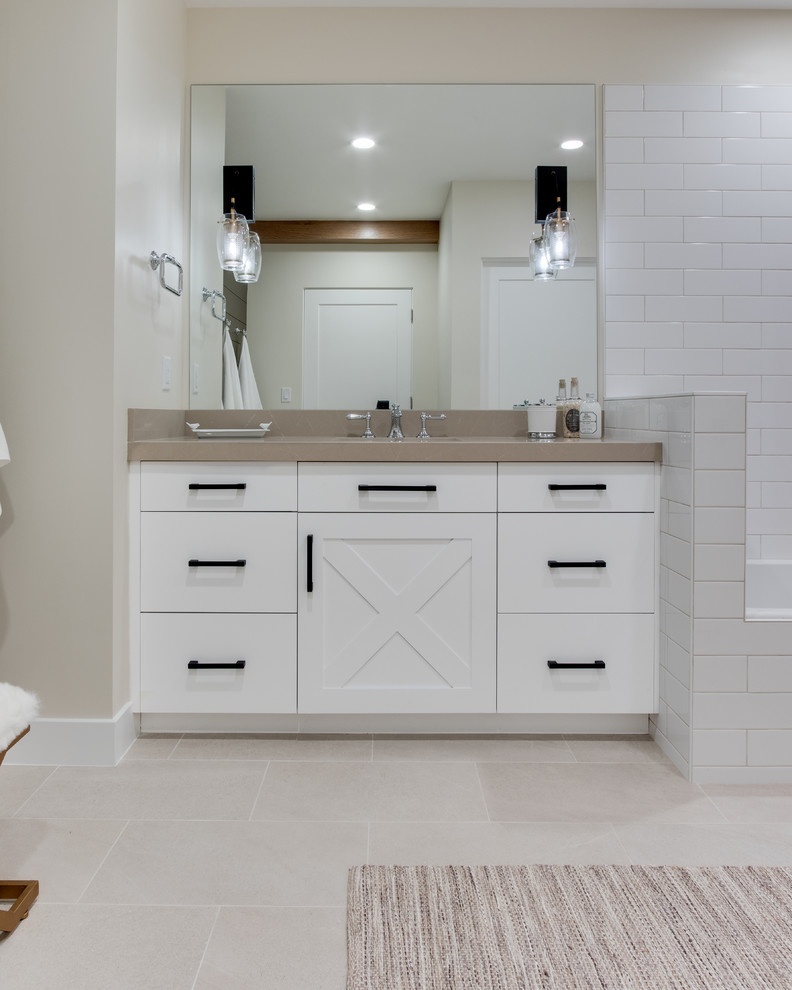 Photo of a country 3/4 bathroom in Salt Lake City with shaker cabinets, white cabinets, a shower/bathtub combo, a one-piece toilet, multi-coloured tile, white walls, ceramic floors, an undermount sink, beige floor, an open shower and beige benchtops.