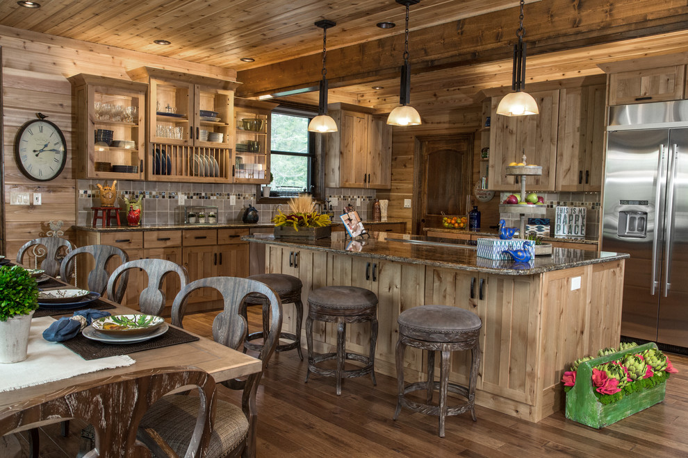 Photo of a country l-shaped eat-in kitchen in St Louis with an undermount sink, shaker cabinets, medium wood cabinets, grey splashback, stainless steel appliances, dark hardwood floors and with island.
