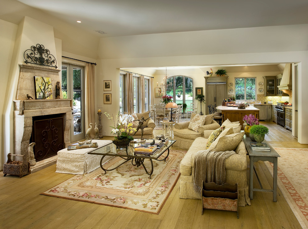 Photo of a mediterranean living room in Santa Barbara with a stone fireplace surround and white walls.