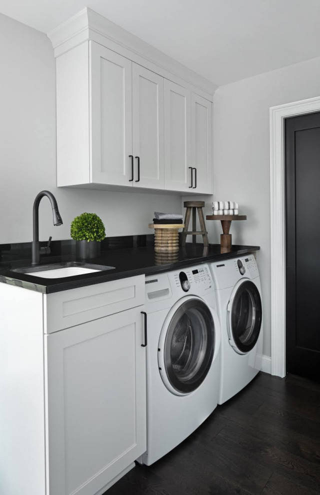 Transitional single-wall dedicated laundry room in Detroit with an undermount sink, shaker cabinets, white cabinets, dark hardwood floors, a side-by-side washer and dryer and black benchtop.