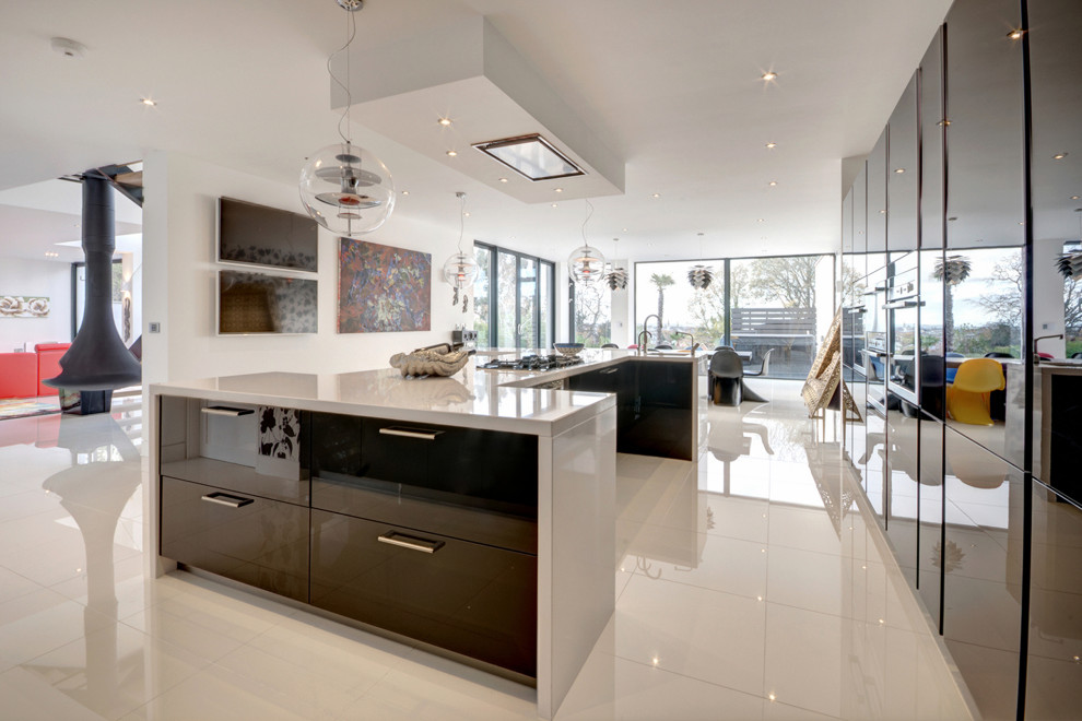 Expansive contemporary kitchen in Gloucestershire with flat-panel cabinets, black cabinets and white benchtop.