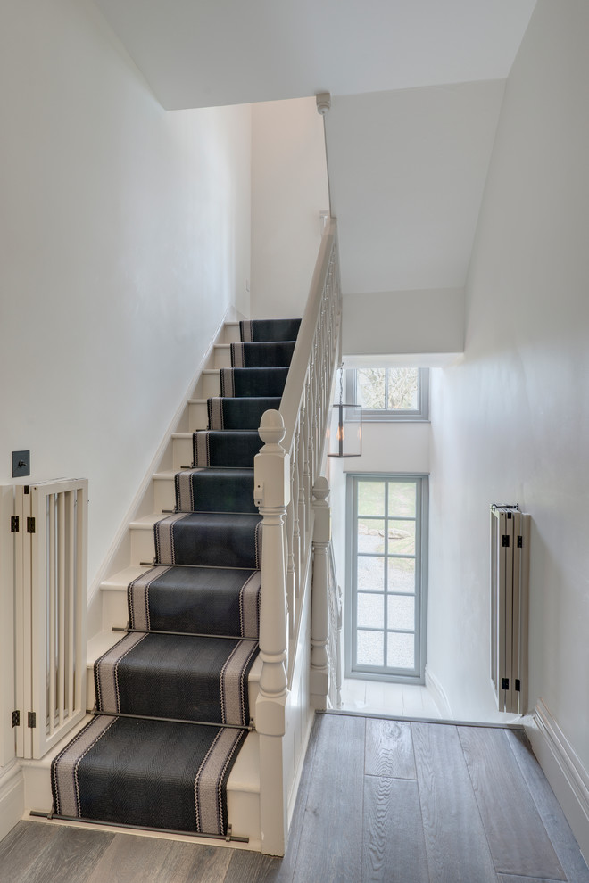 This is an example of a mid-sized country hallway in Devon with grey walls, dark hardwood floors and brown floor.