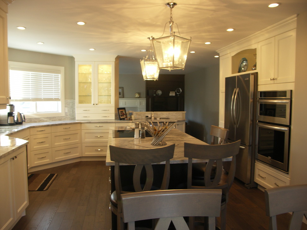 Eat-in kitchen - mid-sized transitional u-shaped medium tone wood floor and brown floor eat-in kitchen idea in Edmonton with recessed-panel cabinets, white cabinets, an undermount sink, stainless steel appliances, an island, marble countertops, gray backsplash and matchstick tile backsplash