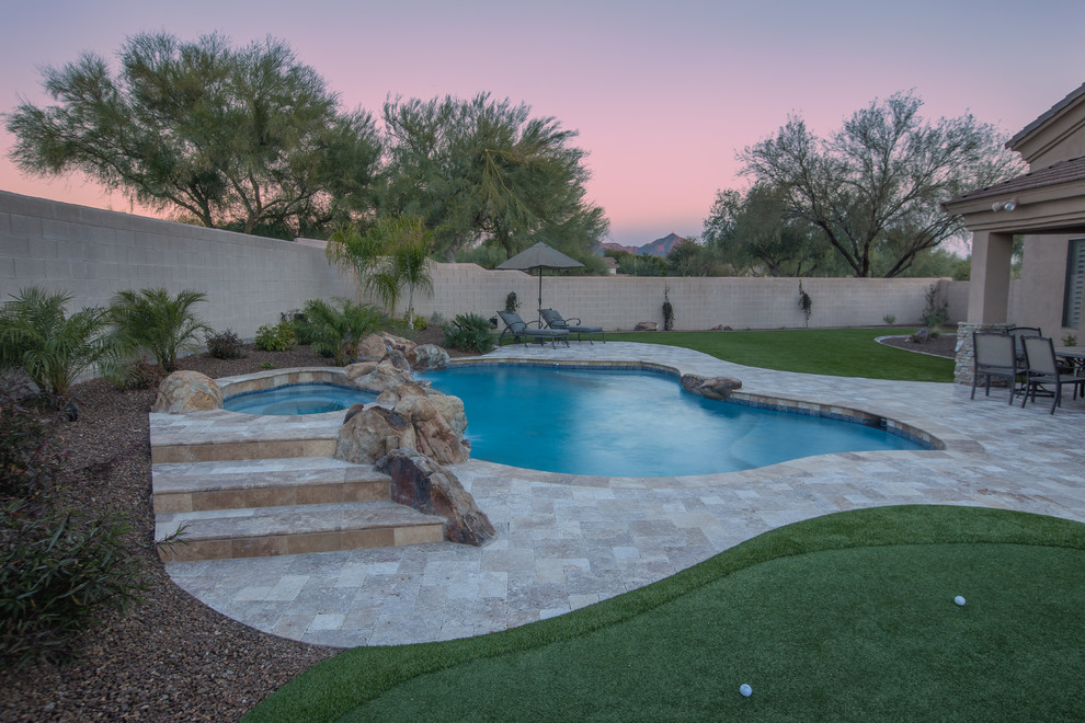 Mid-sized tuscan backyard tile and custom-shaped hot tub photo in Phoenix