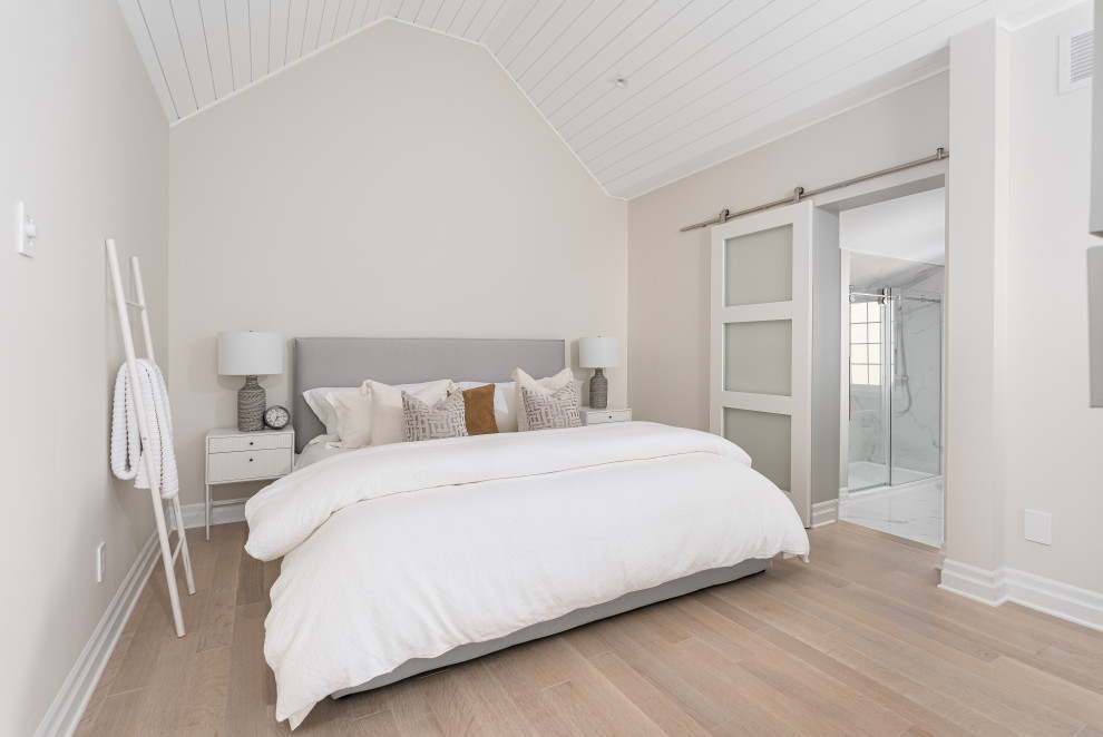 Ejemplo de dormitorio machihembrado y principal contemporáneo grande con paredes beige, suelo de madera clara, chimenea de doble cara y machihembrado