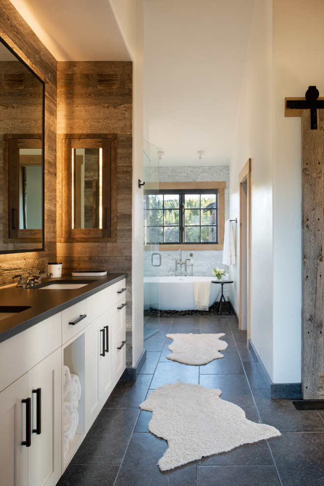 Mid-sized country master bathroom in Other with flat-panel cabinets, white cabinets, a freestanding tub, a corner shower, white walls, grey floor, a hinged shower door, black benchtops, an enclosed toilet, a double vanity, a built-in vanity and vaulted.