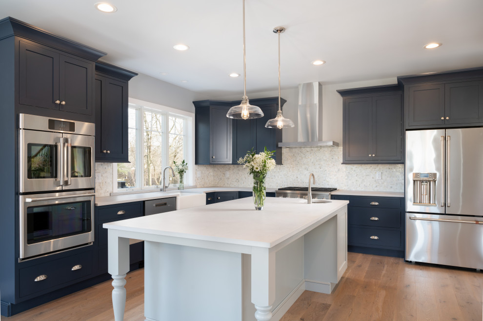 Klassische Küche mit Schrankfronten im Shaker-Stil, blauen Schränken, Kücheninsel, braunem Boden und weißer Arbeitsplatte in Philadelphia