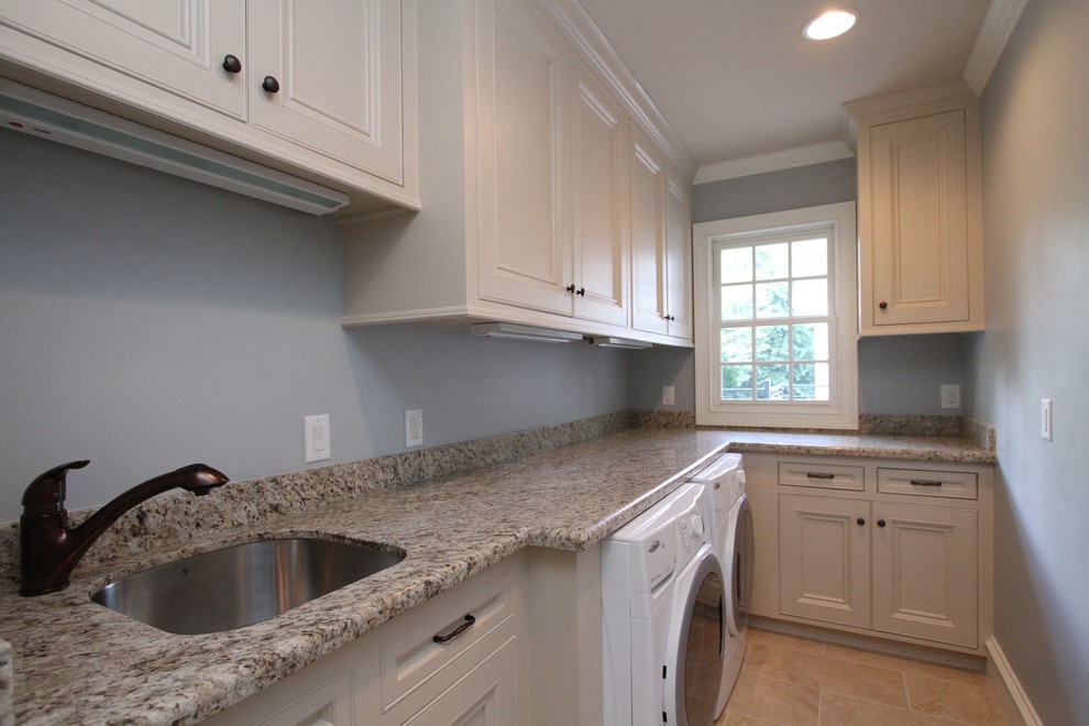 Photo of a mid-sized traditional l-shaped dedicated laundry room in Houston with an undermount sink, beaded inset cabinets, white cabinets, granite benchtops, travertine floors and a side-by-side washer and dryer.