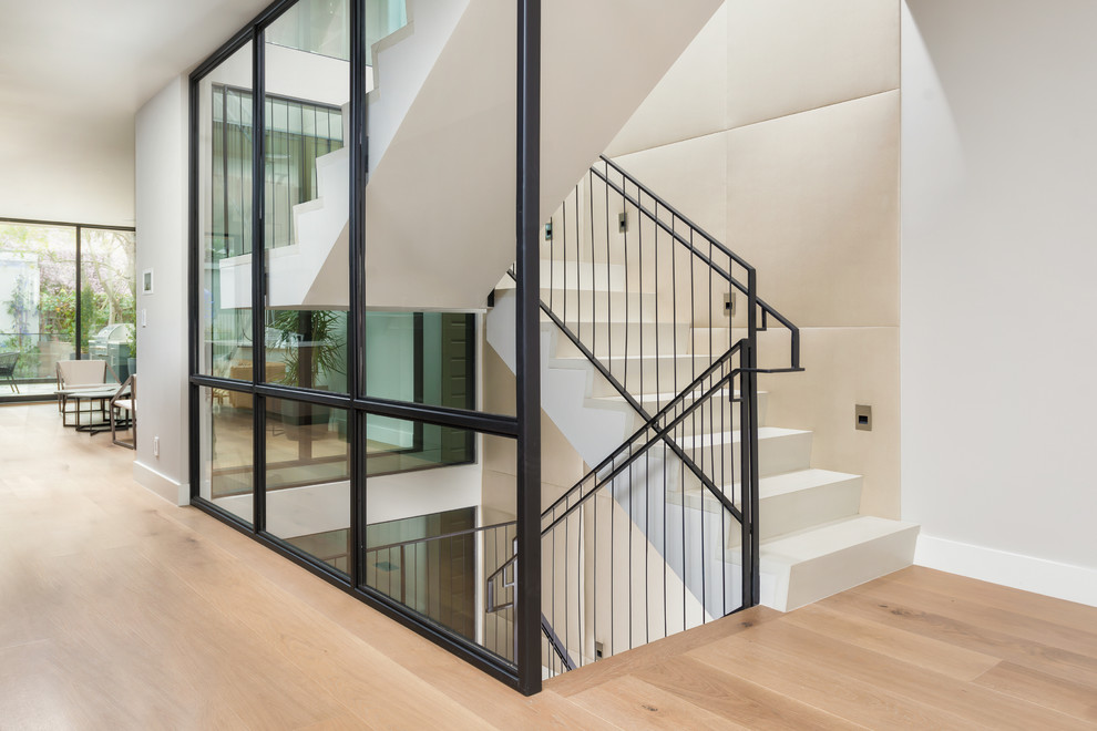 Photo of a large contemporary limestone u-shaped staircase in San Francisco with mixed railing and limestone risers.
