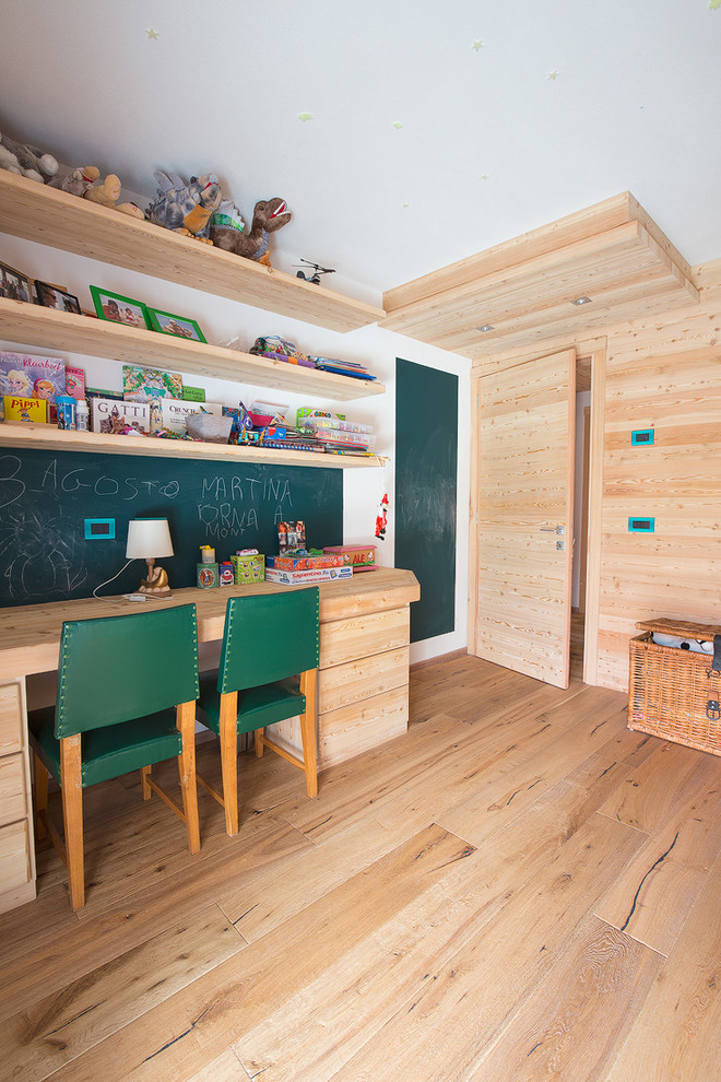 Design ideas for a scandinavian gender-neutral kids' study room for kids 4-10 years old in Milan with white walls and light hardwood floors.