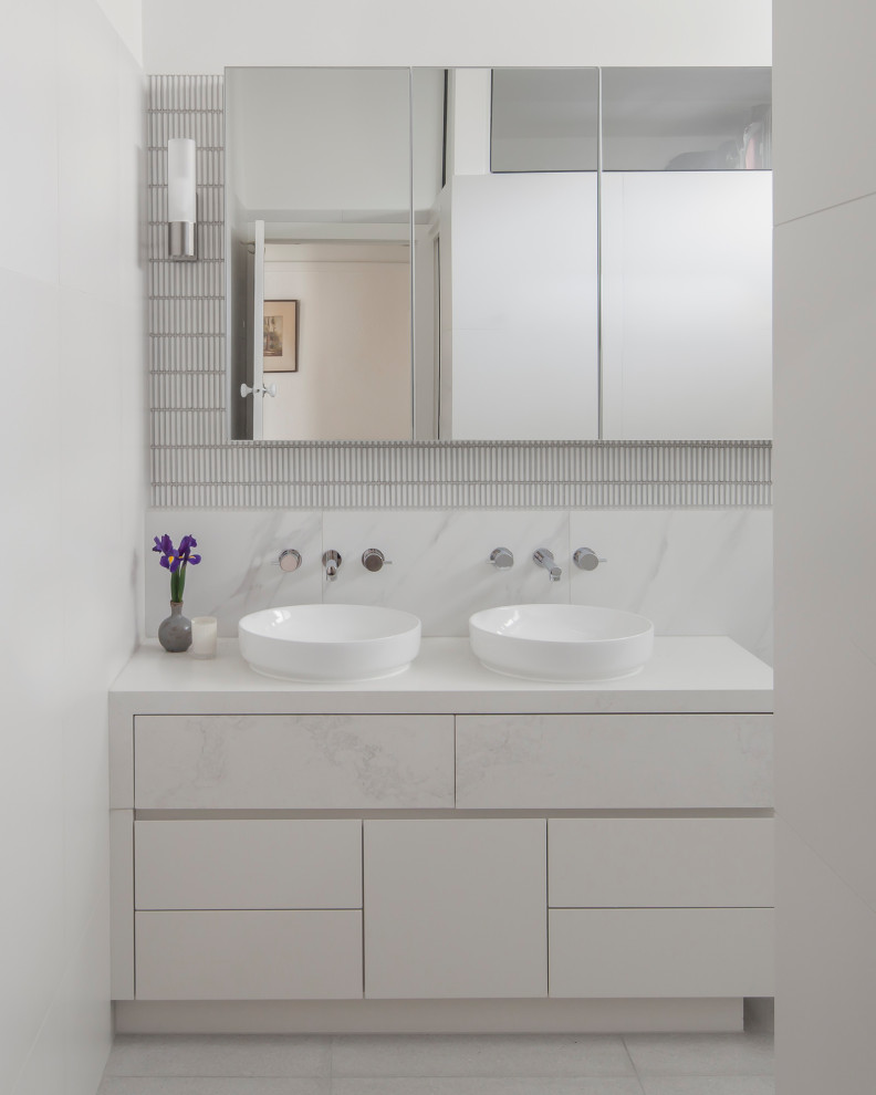 Photo of a mid-sized contemporary master bathroom in Melbourne with flat-panel cabinets, white cabinets, an open shower, a wall-mount toilet, white tile, ceramic tile, white walls, porcelain floors, a vessel sink, engineered quartz benchtops, white floor, an open shower, white benchtops, a niche, a double vanity and a built-in vanity.