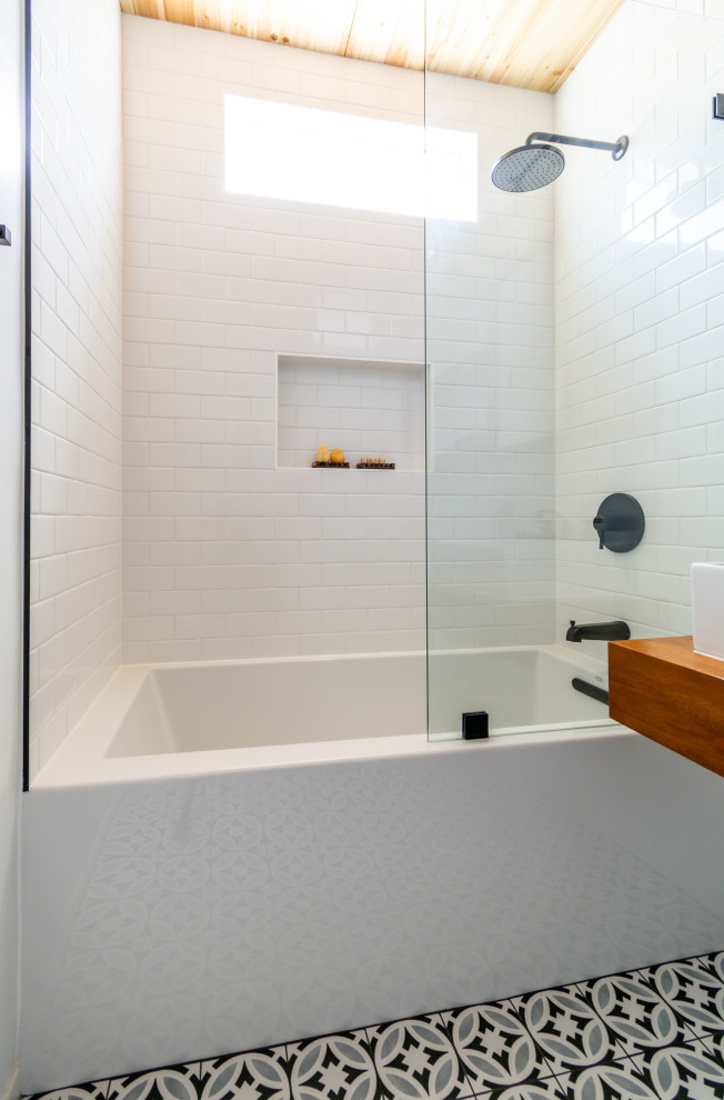 Design ideas for a mid-sized modern 3/4 bathroom in Los Angeles with dark wood cabinets, a drop-in tub, a shower/bathtub combo, a bidet, white tile, subway tile, white walls, mosaic tile floors, a drop-in sink, wood benchtops, black floor, an open shower, brown benchtops, a single vanity, a floating vanity and wood.