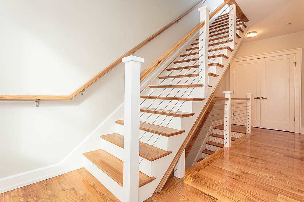 This is an example of an expansive modern wood straight staircase in Boston with painted wood risers.