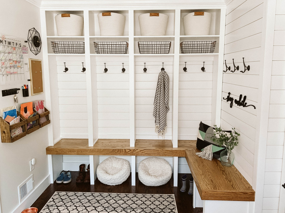 Inspiration for a mid-sized country mudroom in Detroit with white walls, dark hardwood floors and brown floor.