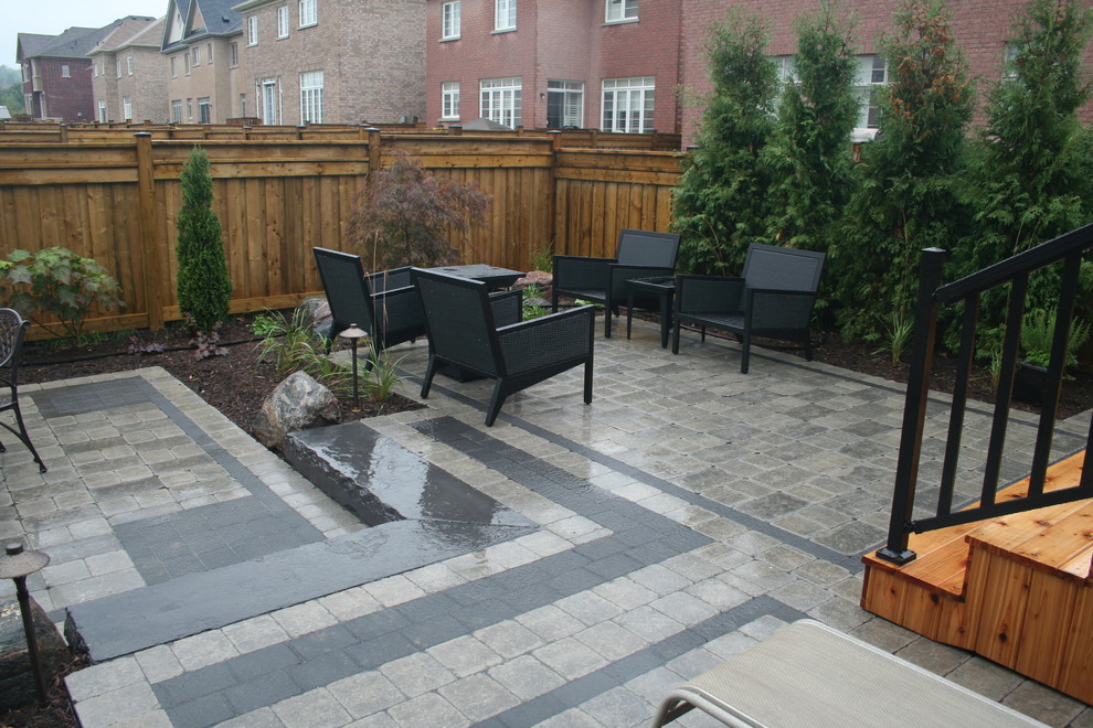 Inspiration for a small modern backyard full sun formal garden for summer in Toronto with concrete pavers.