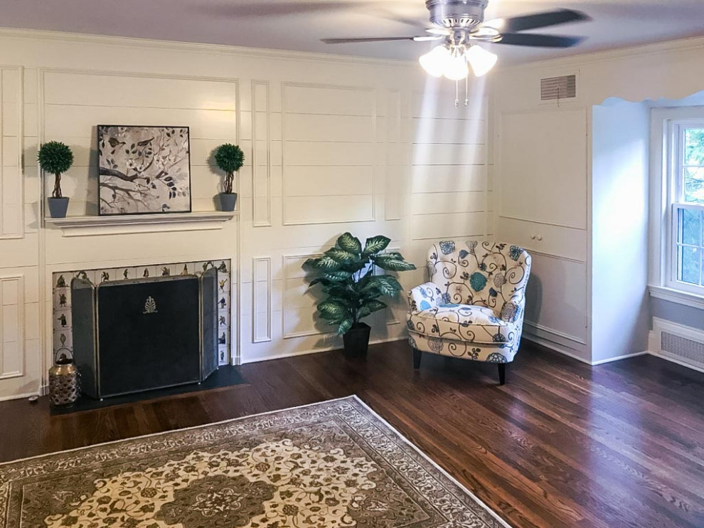 Inspiration for a large traditional master bedroom in Cleveland with white walls, dark hardwood floors, a standard fireplace, brown floor and planked wall panelling.