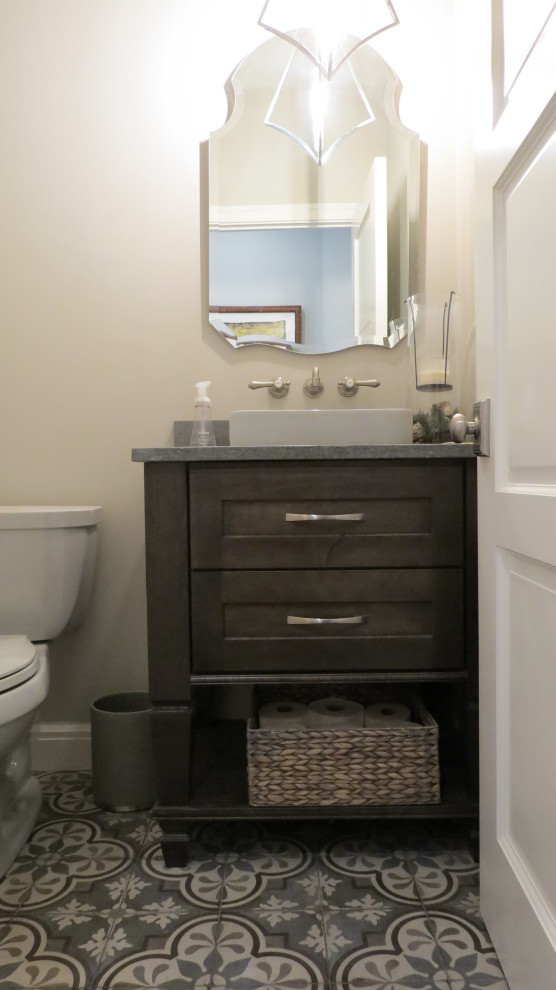 Photo of a small transitional powder room in Detroit with flat-panel cabinets, dark wood cabinets, beige walls, porcelain floors, a vessel sink, solid surface benchtops, grey floor, grey benchtops and a freestanding vanity.