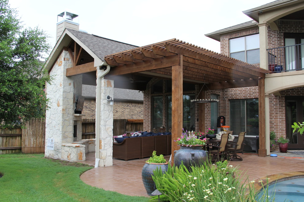 Inspiration for a large traditional backyard patio in Houston with a fire feature, stamped concrete and a roof extension.