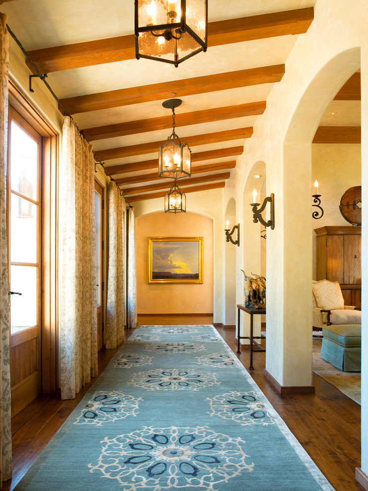 This is an example of a mediterranean hallway in San Francisco with beige walls and dark hardwood floors.