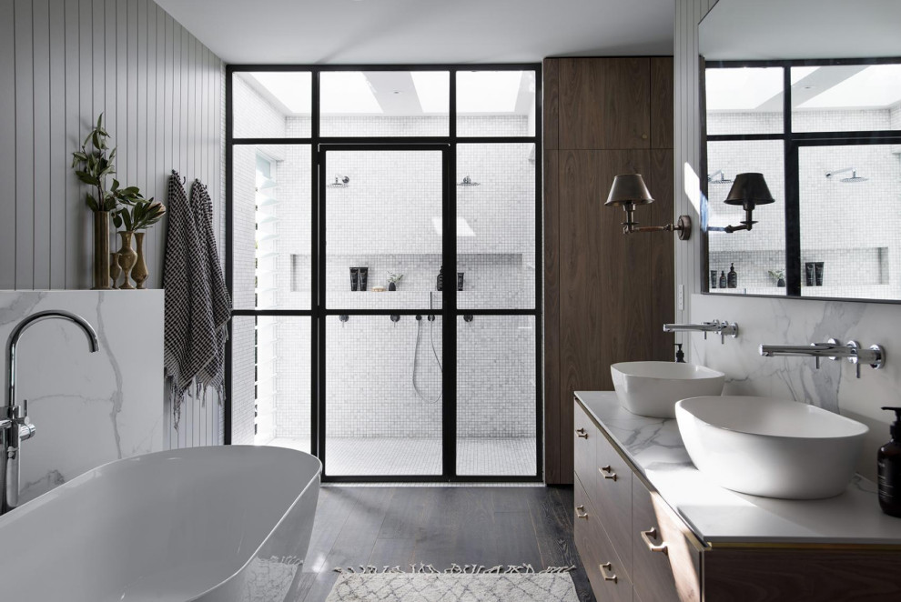 This is an example of a contemporary bathroom in Gold Coast - Tweed with flat-panel cabinets, dark wood cabinets, a freestanding tub, white tile, mosaic tile, grey walls, dark hardwood floors, a vessel sink, brown floor, white benchtops, a niche, a double vanity, a floating vanity and planked wall panelling.