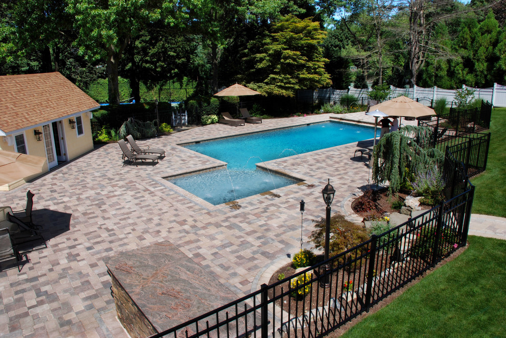 This is an example of a traditional backyard rectangular pool in New York with concrete pavers.