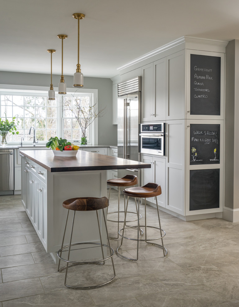 Contemporary u-shaped separate kitchen in Boston with a farmhouse sink, shaker cabinets, white cabinets, stainless steel appliances, with island, grey floor, wood benchtops, multi-coloured splashback and ceramic splashback.