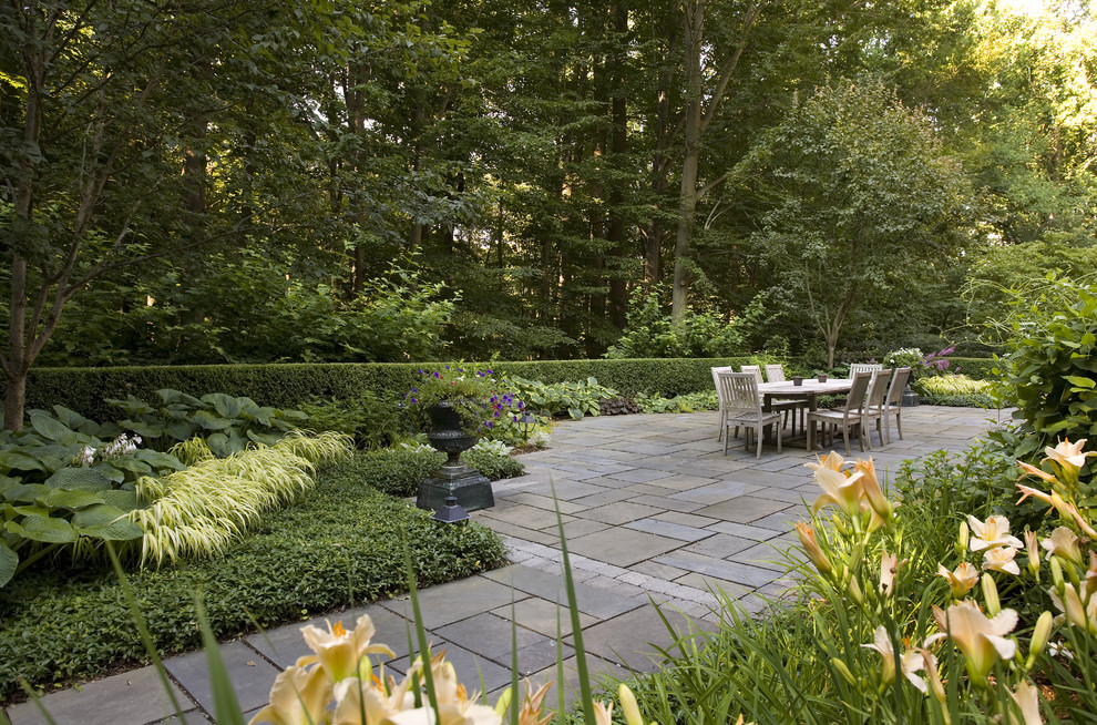 This is an example of a traditional backyard shaded garden in New York with natural stone pavers.