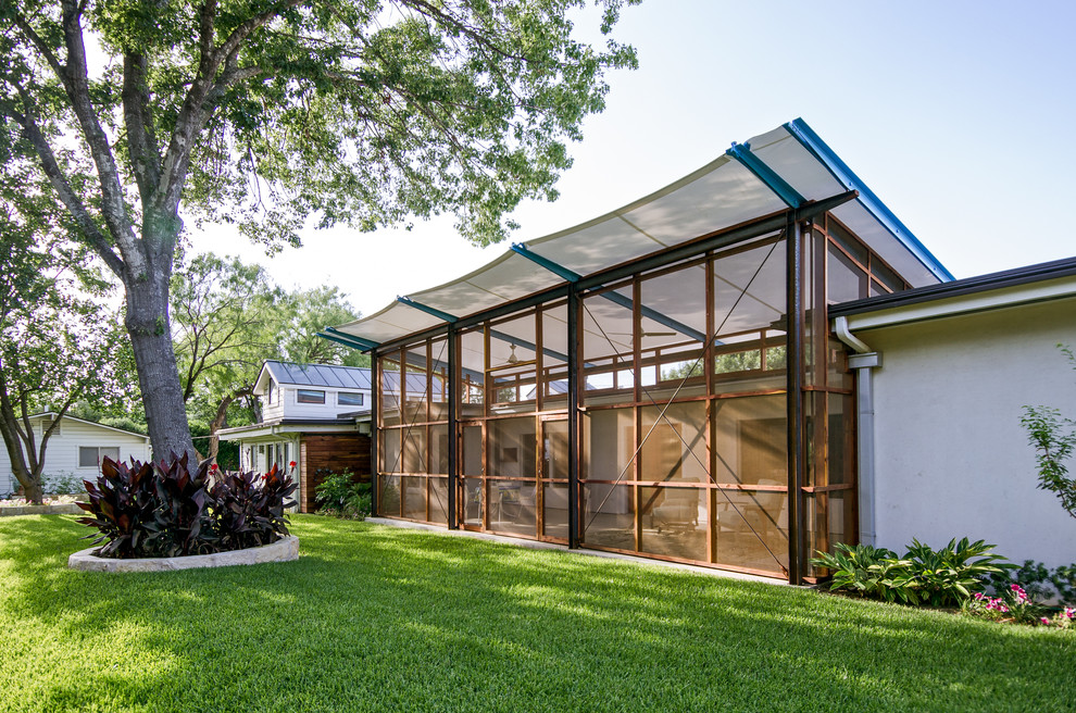 This is an example of a contemporary verandah in Austin with a roof extension.