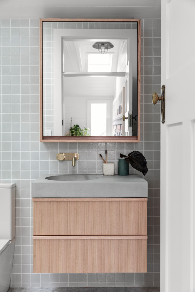 Inredning av ett modernt litet grå grått en-suite badrum, med bruna skåp, ett platsbyggt badkar, en öppen dusch, en toalettstol med separat cisternkåpa, vit kakel, keramikplattor, vita väggar, kalkstensgolv, ett väggmonterat handfat, bänkskiva i betong, grått golv och med dusch som är öppen