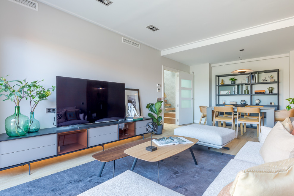 Esempio di un soggiorno contemporaneo di medie dimensioni e chiuso con pareti grigie, parquet chiaro, TV autoportante, pavimento marrone e pareti in legno