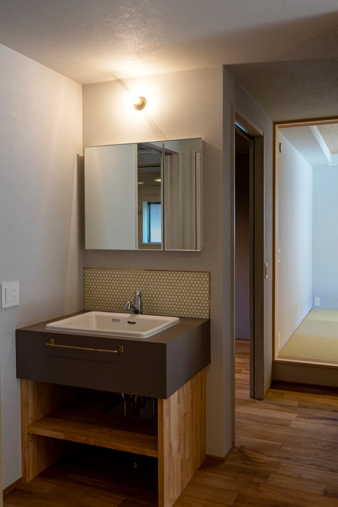 Ispirazione per un piccolo bagno di servizio moderno con piastrelle a mosaico, lavabo a consolle e mobile bagno freestanding