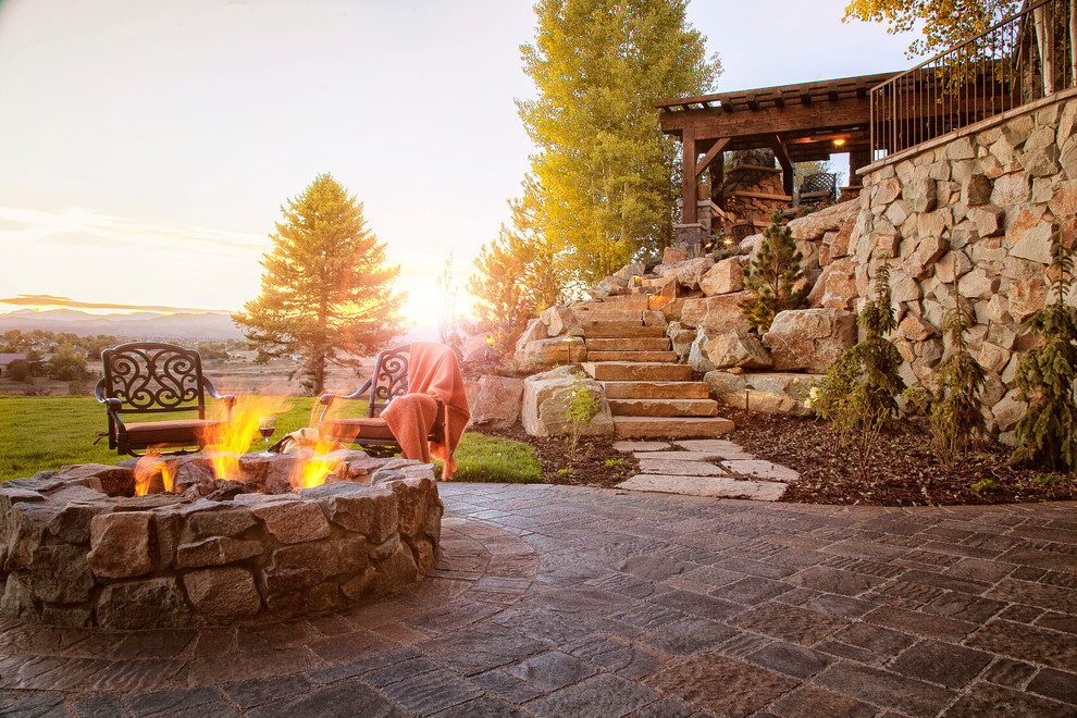 Photo of a large country backyard partial sun garden in Denver with a fire feature and concrete pavers.