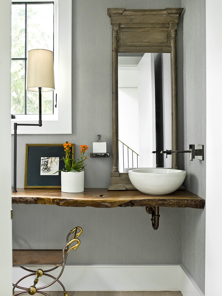 Inspiration for a country powder room in Chicago with grey walls, a vessel sink, wood benchtops, brown floor and brown benchtops.