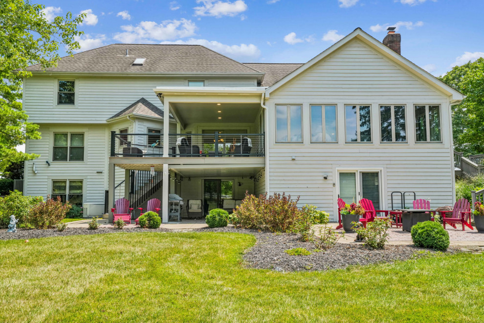 Example of a mid-sized transitional backyard second story cable railing deck design in Columbus with a roof extension