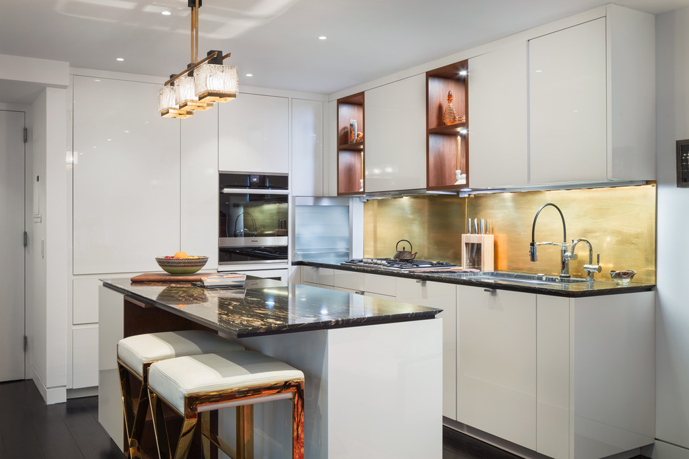 Mid-sized modern galley eat-in kitchen in New York with an undermount sink, flat-panel cabinets, white cabinets, marble benchtops, panelled appliances, dark hardwood floors, with island, black floor and black benchtop.