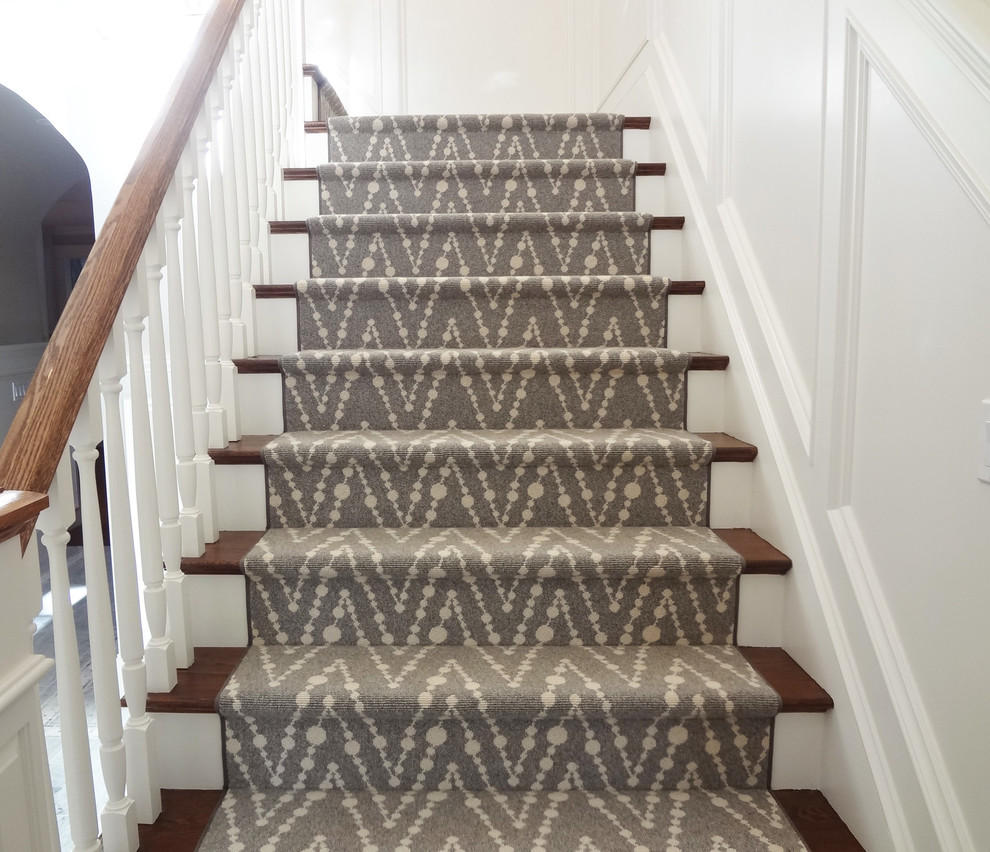 This is an example of a mid-sized transitional carpeted straight staircase in Boston with carpet risers.