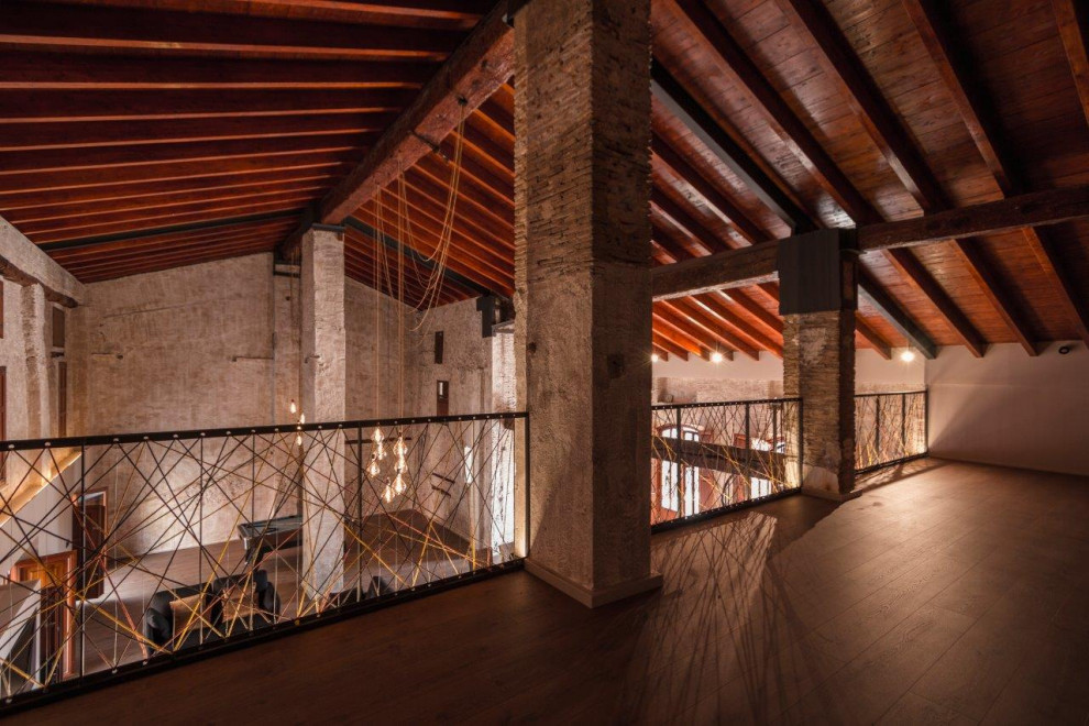 Diseño de sala de estar abierta contemporánea grande con suelo de madera en tonos medios, televisor colgado en la pared y vigas vistas