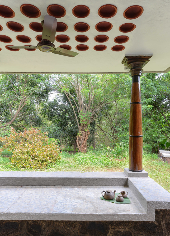 Inspiration for a large country balcony in Mumbai with with privacy feature, a roof extension and mixed railing.