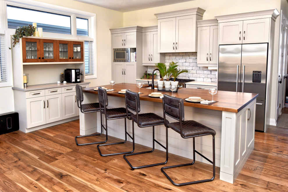 Kitchen - mid-sized craftsman medium tone wood floor kitchen idea in Toronto with a double-bowl sink, recessed-panel cabinets, gray cabinets, solid surface countertops, multicolored backsplash, porcelain backsplash, stainless steel appliances, an island and white countertops
