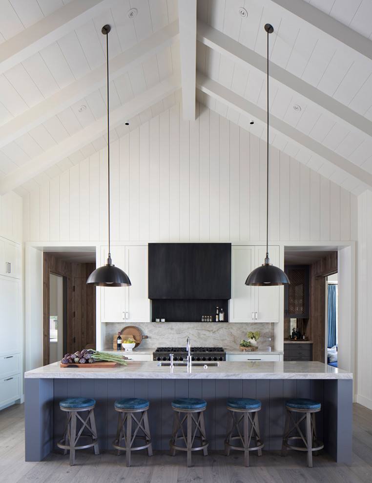 Country u-shaped dark wood floor, brown floor and vaulted ceiling kitchen photo in San Francisco with an undermount sink, shaker cabinets, white cabinets, stainless steel appliances, an island, gray countertops, gray backsplash and stone slab backsplash