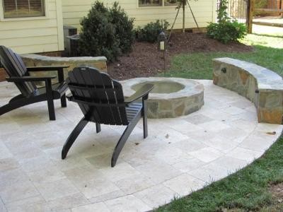 This is an example of a mid-sized traditional backyard patio in Other with a fire feature, natural stone pavers and no cover.